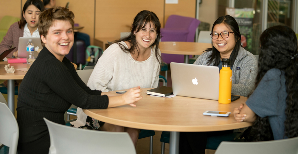 group of female students at table smiling