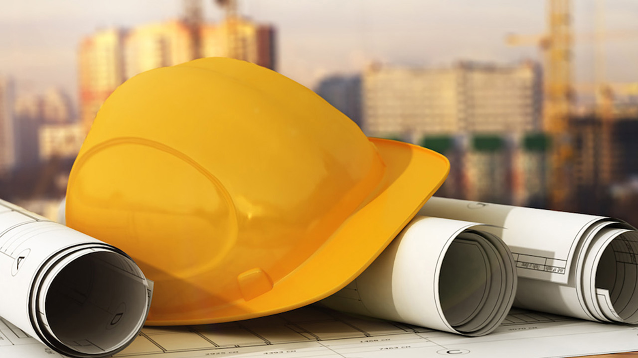 skyline with hard hat and blueprints in the foreground