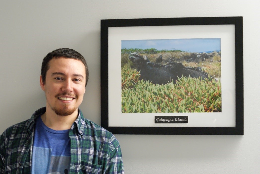 IEP Student Francisco Astorga poses with a photo of an Iguana from Galapagos Island