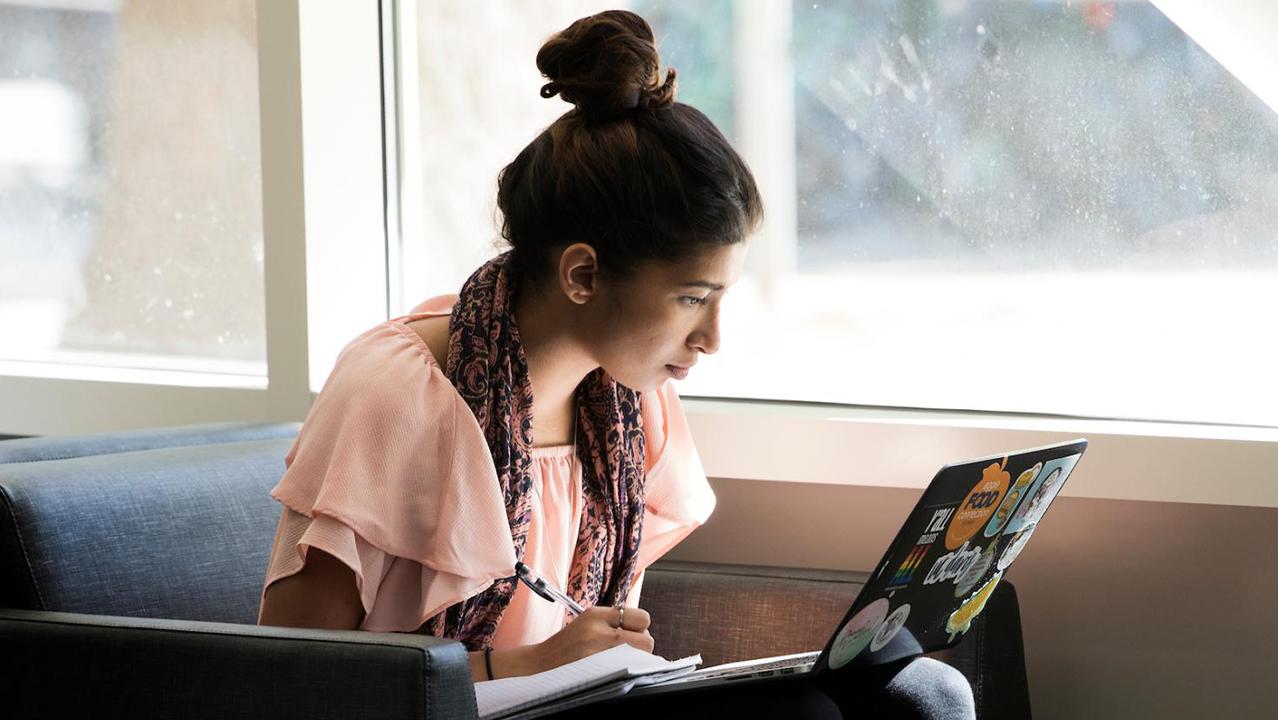 student sitting in chair on laptop