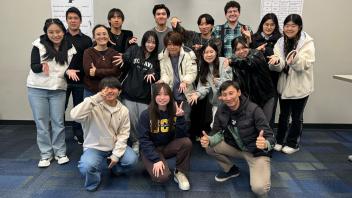 A group of international students at UC Davis pose inside for a group photo
