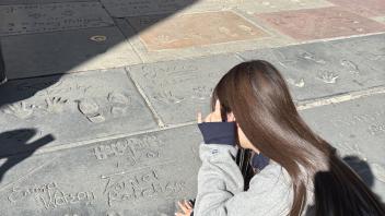 Hikaru Fujiwara putting her hand on a bill by Daniel Radcliffe (Harry Potter)