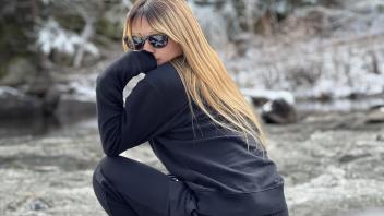 a student poses for a photo in Yosemite with snowy trees in the background
