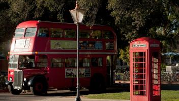 A vintage English double-decker bus pulls in to the station at UC Davis' Memorial Union Terminal