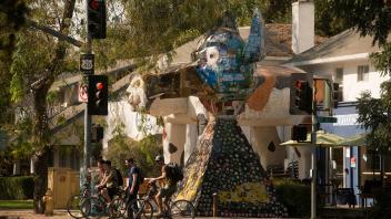 People cross the street in front of the John Natsoulas Gallery on E street in downtown Davis 