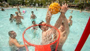 students play basketball in the pool