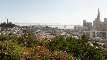 The view of the Bay Bridge, Coit Tower and downtown from Ina Coolbrith Park in San Francisco