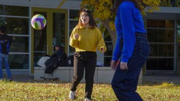 international students play volleyball outside the International Center