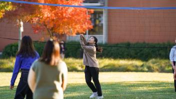 international students play volleyball outside the International Center