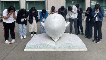 Seikei High School students pose next to the Bookhead Egghead