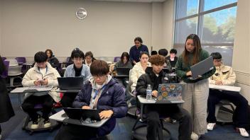 a group of students get help setting up their computers 