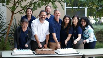 UC Davis GSP staff pose while cutting 20th anniversary cake