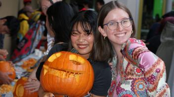 UC Davis international students show off their pumpkin carving skills at a Halloween party