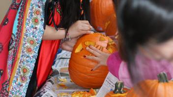 UC Davis international students carve pumpkins at a Halloween party