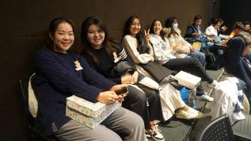 students sit in chairs waiting to watch the show