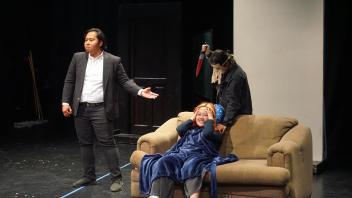 three students perform a scary scene on stage