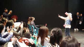 GSP student performs on stage as her classmates cheer her on