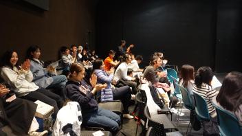 students sit in the audience cheering on their classmates