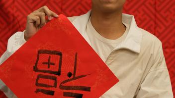 A GSP student shows off his Year of the Snake calligraphy