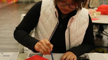 A GSP student paints calligraphy during a Lunar New Year celebration