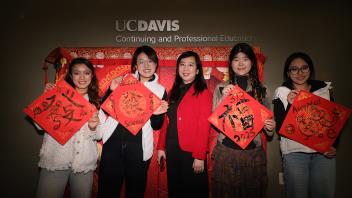 GSP students pose with their calligraphy next to staff member Xin Chen