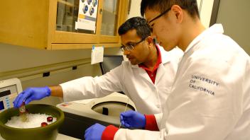 A GREAT program student and Professor Padavannil transfer a sample into the cooling bucket during their experiment