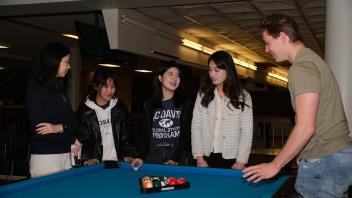 a group of students gets ready to play billiards