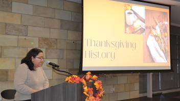 Student assistant Nicole Purba gives a presentation on the history of Thanksgiving before eating