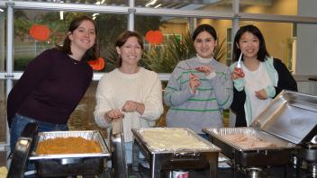 international students pose for a photo before serving food during the Thanksgiving celebration