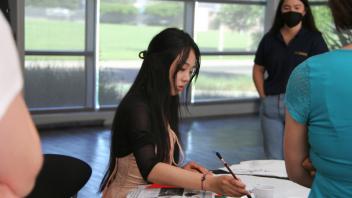 YiFei Li paints as people watch on