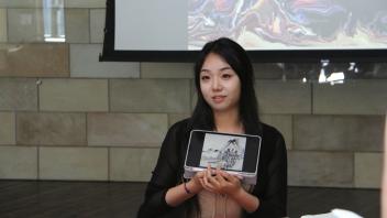YiFei Li shows an example of a painting on a tablet during her workshop