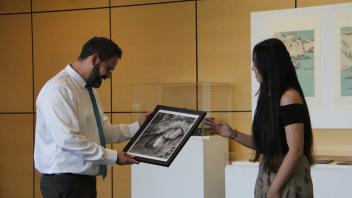 YiFei Li presents a painting to GSP director Jake Hosier
