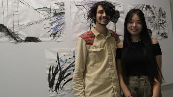YiFei Li and friend pose in front of her paitings