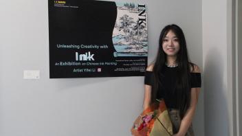 YiFei Li poses next to her art workshop poster