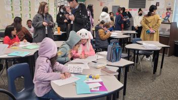 Elementary students in a classroom interacting with Fulbright teachers