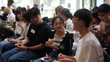 Global Study Program students sit smiling in the UC Davis International Center for orientation