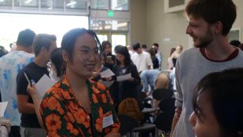 A Global Study Program student talks to two other students during orientation