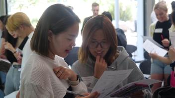 Two Global Study Program students study a worksheet while engaging in an activity during orientation