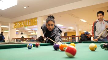 students play billiards in the Memorial Union games area