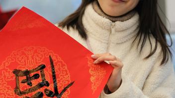 GSP student Shuyi Li poses with Chinese calligraphy
