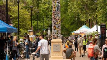 a view of a busy walkway in Central Park, downtown Davis