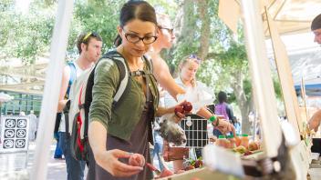 woman at farmers market holding fruit