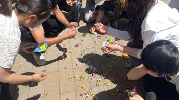 UC Davis international students pick up candy off the floor after the piñata breaks open