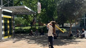 A UC Davis international student gets ready to swing at a piñata for candy during Cinco de Mayo celebrations 