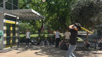 A UC Davis international student swings at a piñata 