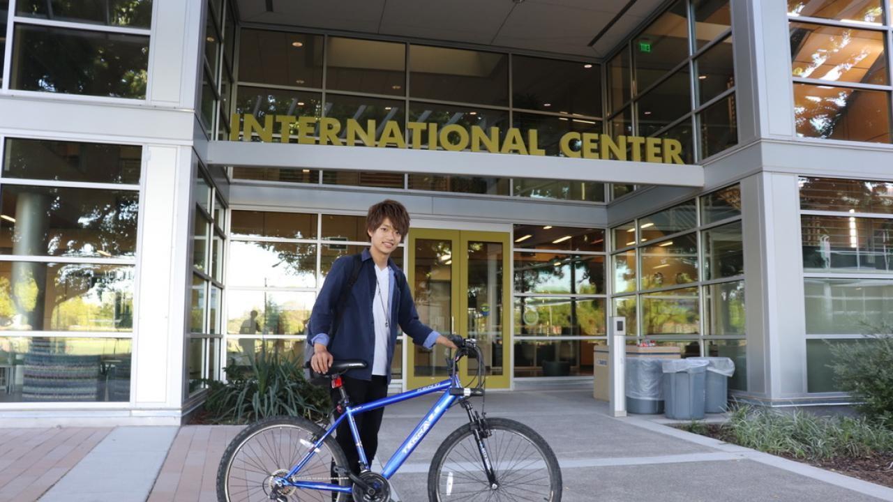 GSP student Ryotaro Sakaguchi poses in front of the Internation Center with his bicycle.