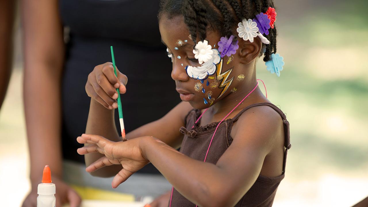 A little girl plays with paint during the Black Family Day celebration at UC Davis