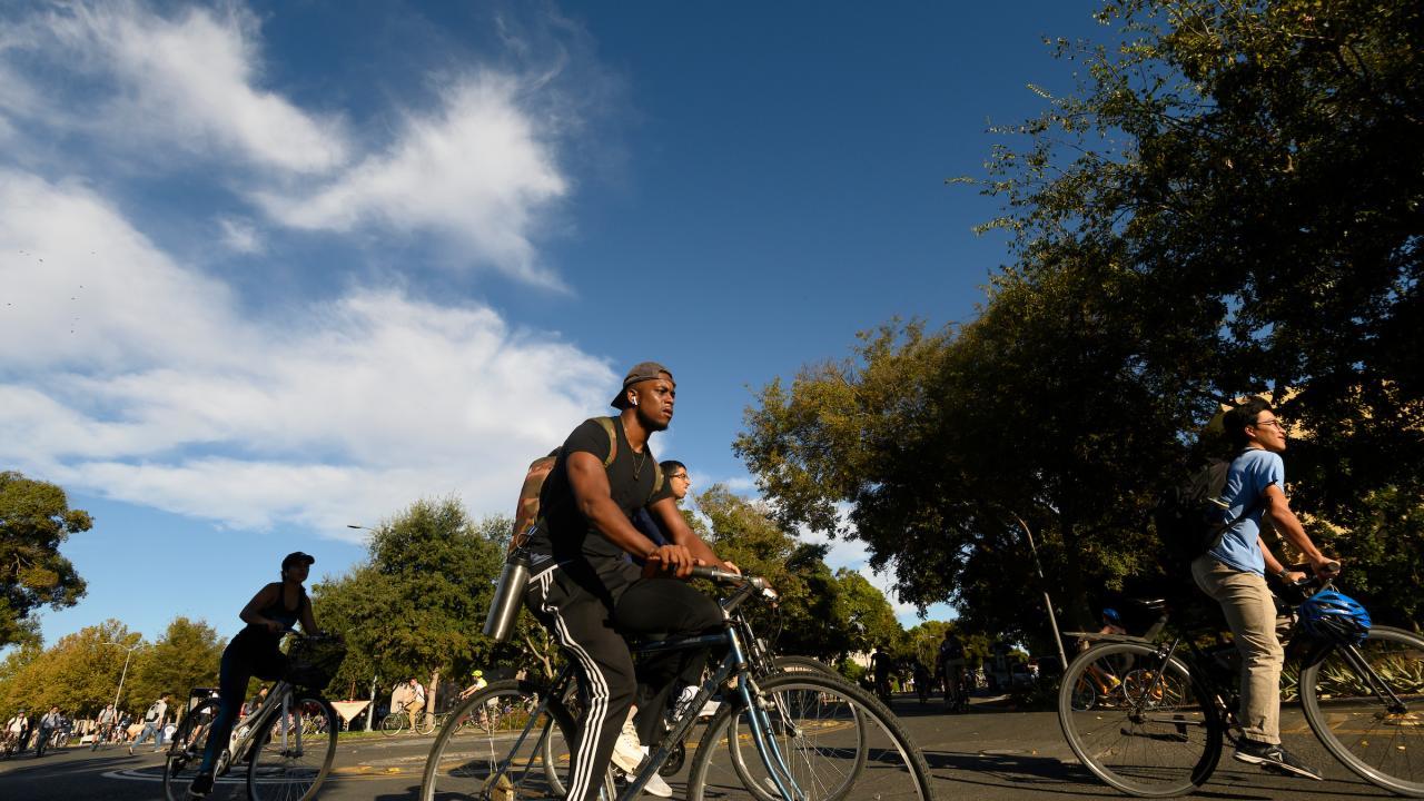 On the first day of classes, students ride their bikes through the bike circle on Hutchison Drive