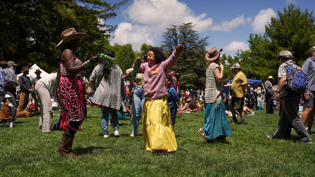 Participants in the Whole Earth Festival dance to the music on the quad