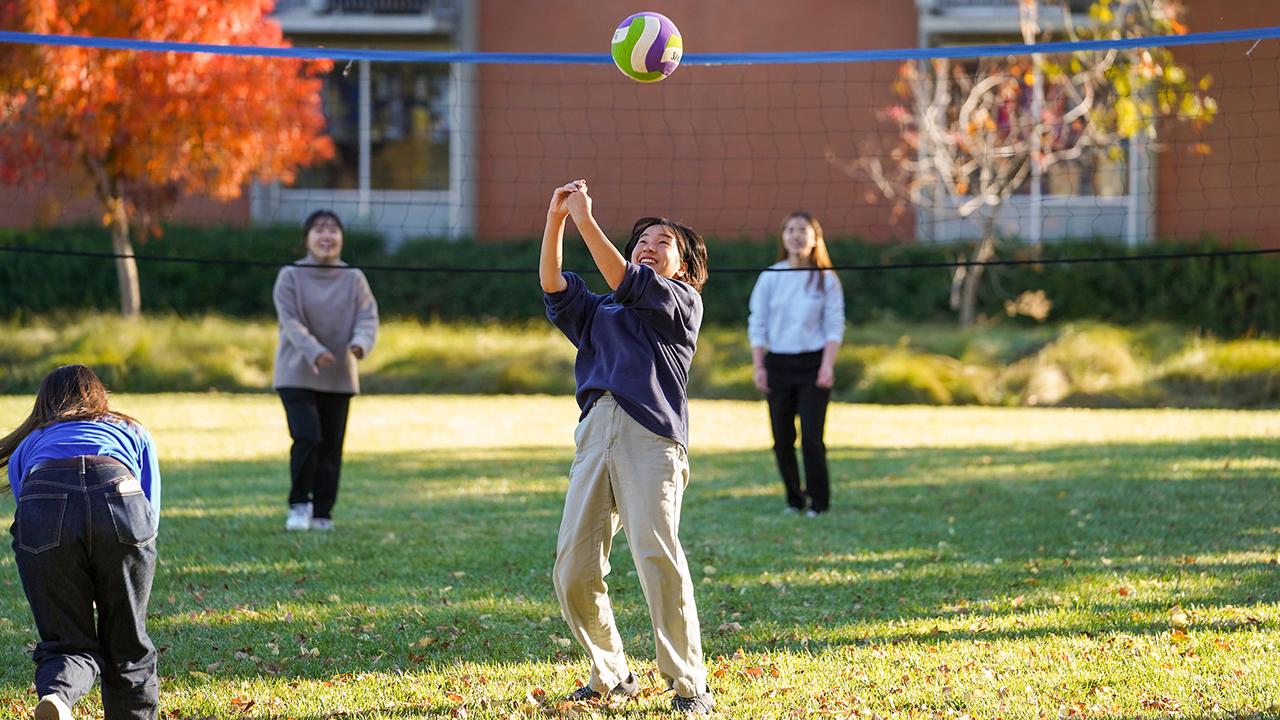 students play a game of volleyball outside the UC Davis International Center
